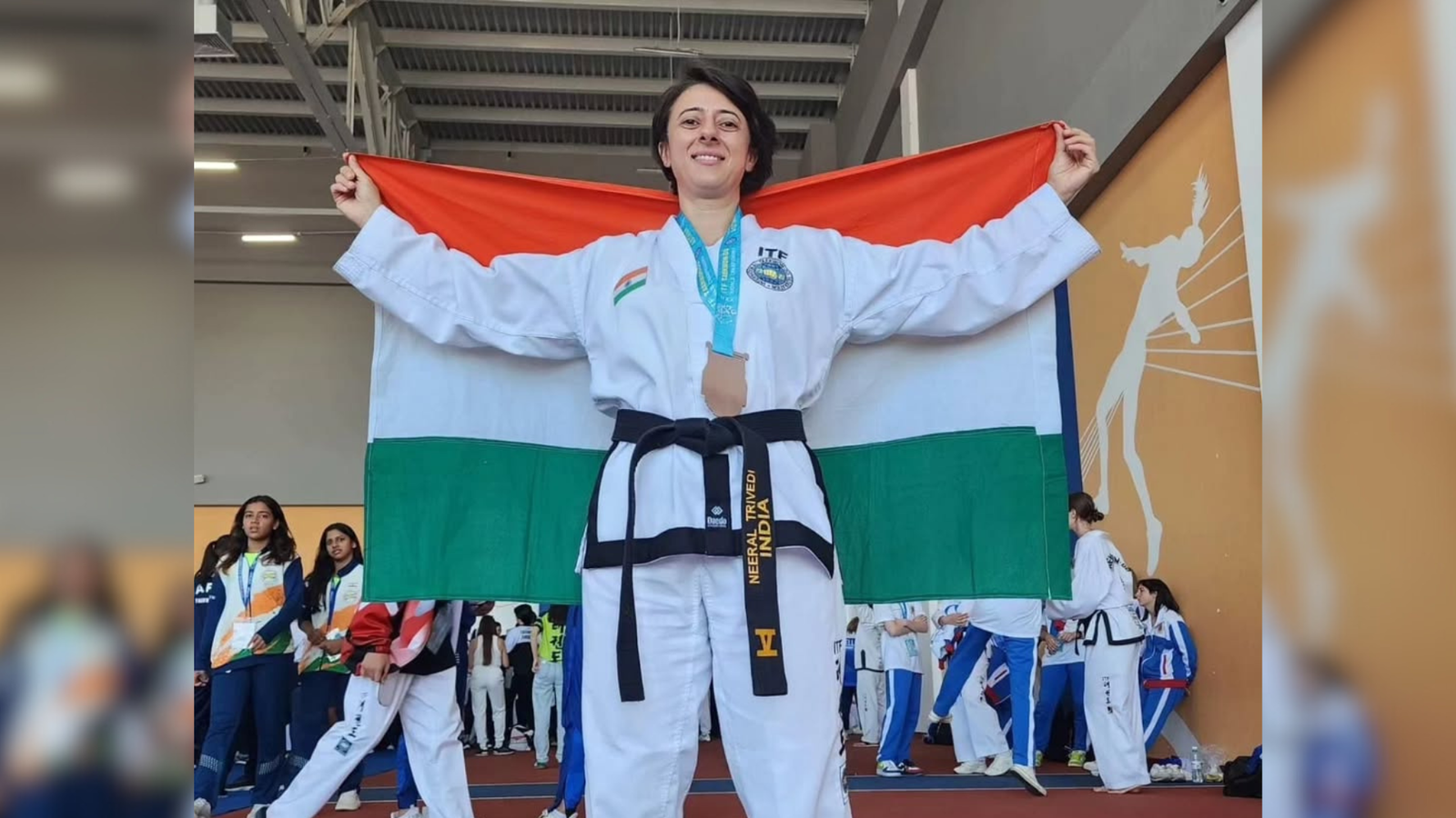 Neeral Trivedi holding the Indian flag after representing India at the Taekwon-Do World Championship